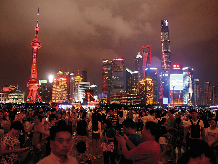 Cheerful crowds stroll the sea front in Pudong district of Shanghai, reminiscent of Hongkong’s embankments; Shanghai is the third city in the world by population, and the world’s largest seaport