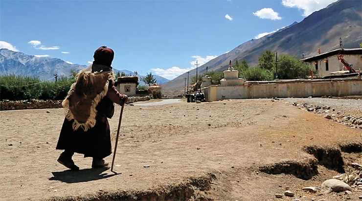 A village woman of Zanskar dressed in traditional clothes. She is walking towards the Sani Monastery