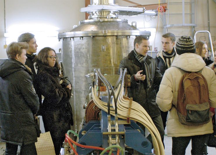 Alexander Makarov, researcher at the BNCT laboratory, explains the working principles of the unique accelerator to a group of secondary school students from Novosibirsk