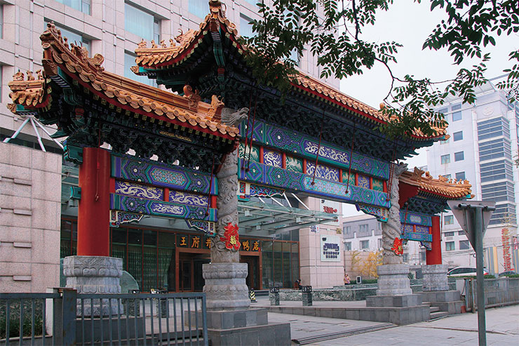 Красочная современная арка перед рестораном «Утка по-пекински на Ванфуцзин»