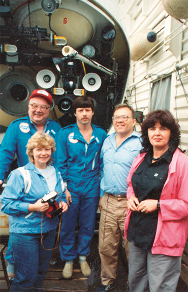 The Dobretsov couple, M. I. Kuzmin, N. M. Sushchevskaya, and the commander of the Mir submersible (its bow section, featuring instruments and lights, appears in the background). 1989