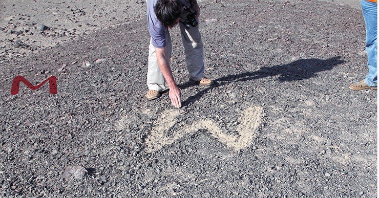 Научный эксперимент: Михаил Гаврилов пытается изобразить первую букву своего имени на пустынном холсте, используя технологию древних. Фото Д. Семенова