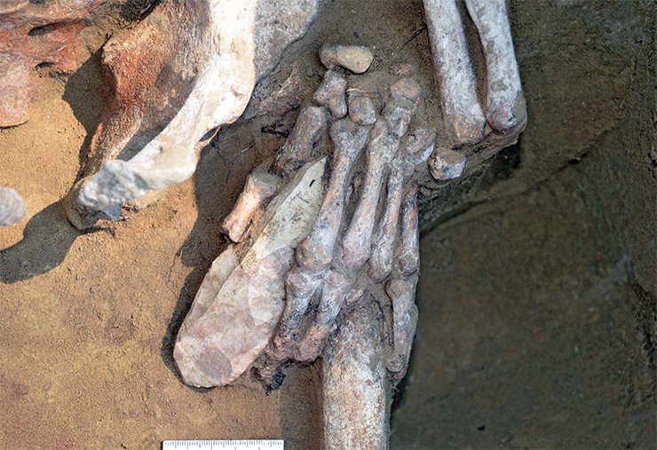 В левой руке основного погребенного зажата массивная каменная пластина