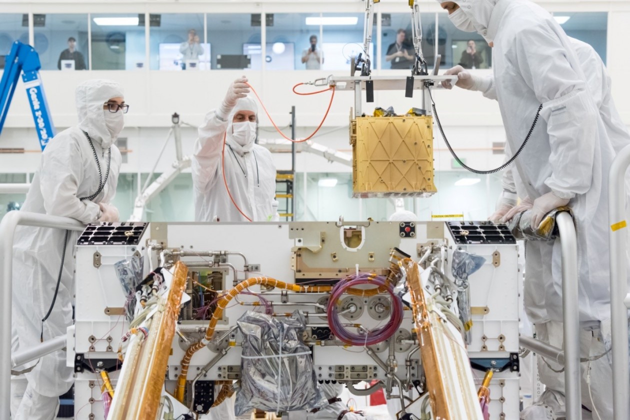 Специалисты осторожно помещают прибор MOXIE внутрь марсохода Perseverance. © NASA/JPL-Caltech
