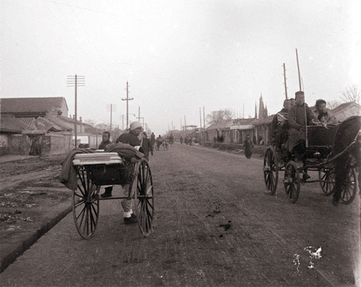 A hutong lane formed by the walls of one-story buildings with courtyards. The vehicles along the walls are rickshaws (above). Left: a rickshaw and horse-drawn carriage on Wangfujing. 1909. Photo by A. Dutertre