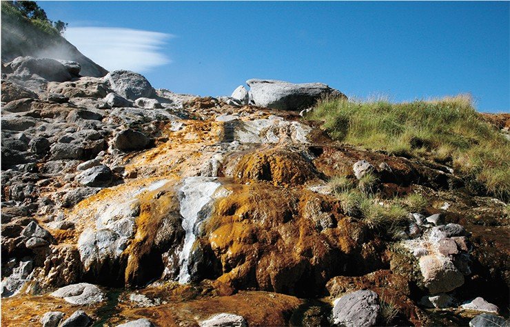 Горячие воды, насыщенные солями, окрашивают скалы в коричневый цвет