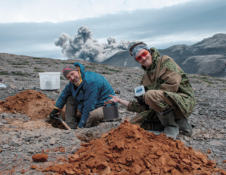The installation of a seismic station on the top of a cliff with Ebeko’s explosion at the background