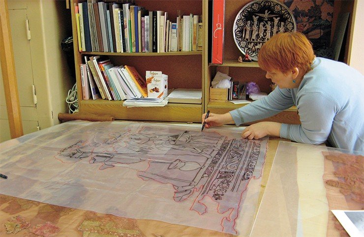Елена Шумакова занята прорисовкой вышитой на шерстяной ткани уникальной композиции, смысл которой пока еще остается загадкой
