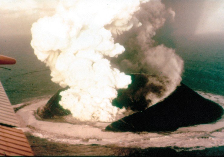 14 ноября 1963 г. черный столб вулканического пепла возвестил о рождении острова на южном побережье Исландии. Извержение началось на глубине 130 м ниже уровня моря и продолжалось, пока высота вулкана не достигла морской поверхности. На фото запечатлен 16-дневный конус вулкана. Фото Х. Уильямса