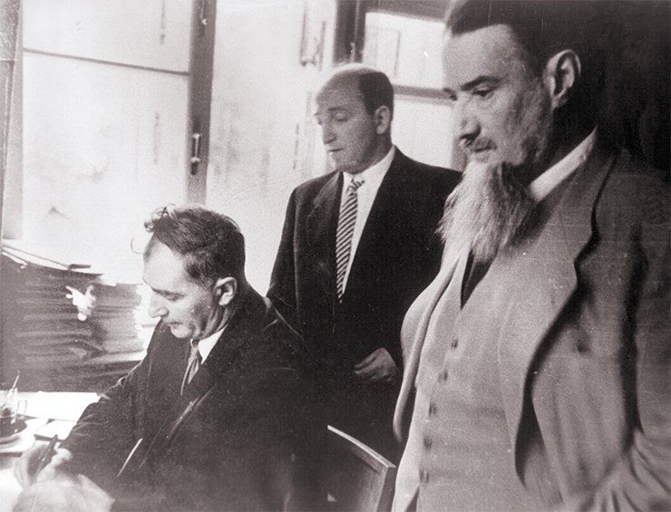 Gersh I. Budker and Igor V. Kurchatov (standing, left to right) at the signing of important documents in Moscow in 1957. SB RAS Photo Archive