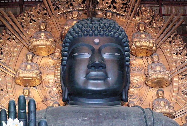 Daibutsu (Giant Buddha). The Buddha from Tōdai-ji is sitting, cross-legged, on a flower-shaped throne. The right hand is stretched forward in blessing. The statue is 16 meters high; the face is 3 meters wide. The eye pits are 1 meter in diameter, – a man can easily go through them