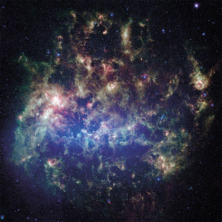 Этa животрепещущая фотография, полученная телескопом Спитцера (NASA), показывает Большое Магелланово облако – спутник нашей галактики Млечный Путь. Большое Магелланово облако находится на расстоянии в 160 000 световых лет от Земли. Это одна из нескольких карликовых галактик, вращающихся вокруг Млечного Пути. Image credit: NASA/JPL-Caltech/STScI