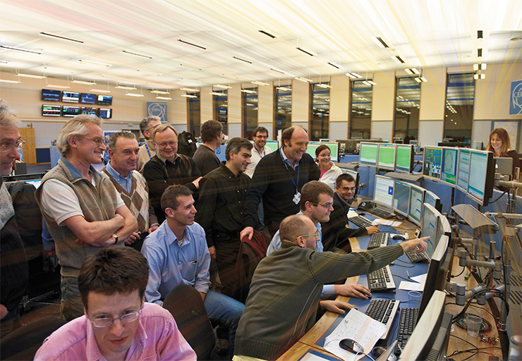 Вскоре после полуночи 30 ноября 2009 г. БАК побил новый мировой рекорд: два пучка протонов внутри ускорителя были разогнаны до энергии 1,18 ТэВ. Фото сделано в Центре контроля ЦЕРН – большом зале, где находятся четыре консоли-«островка», контролирующие Большой адронный коллайдер, протонный синхротрон и суперпротонный синхротрон в цепи впрыска коллайдера и техническую инфраструктуру ускорительного комплекса. © 2009 CERN